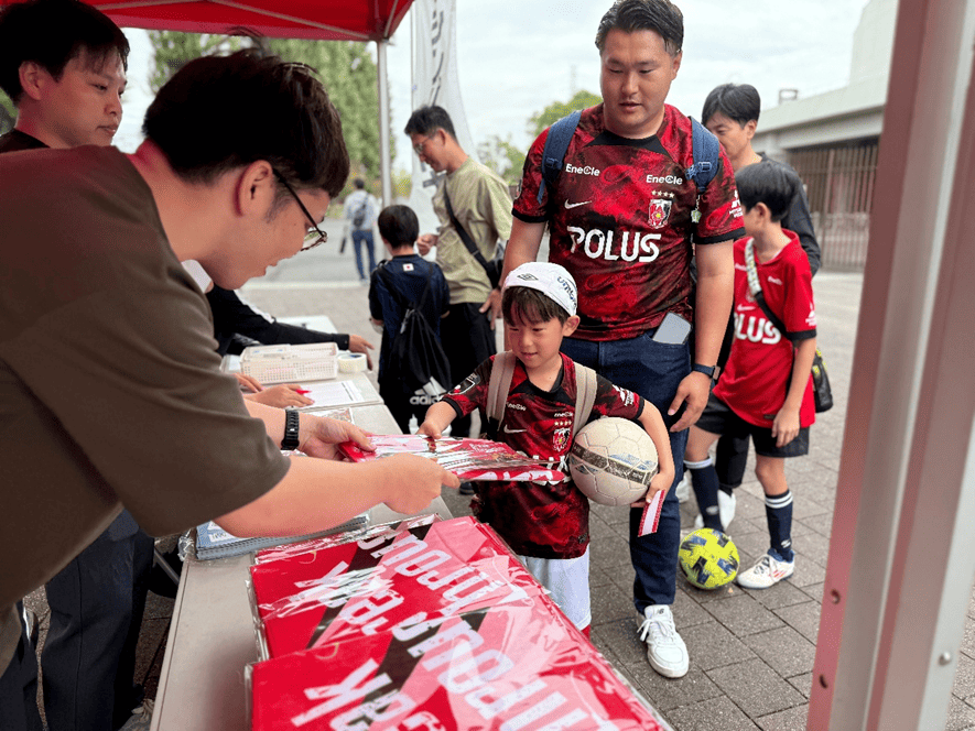 浦和レッズとコラボしたオリジナルタオルやオリジナルクリアファイル配布写真
